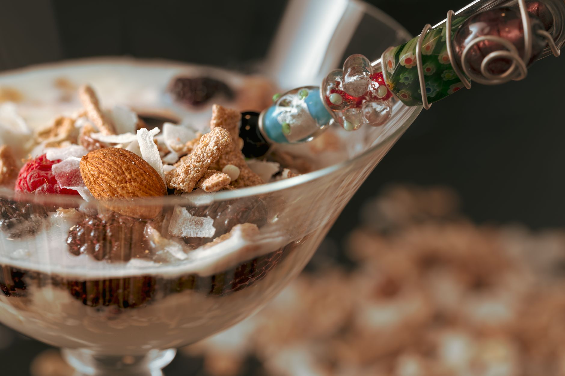 Delicioso parfait de yogur con granola, almendras y frambuesas en una copa de cristal.